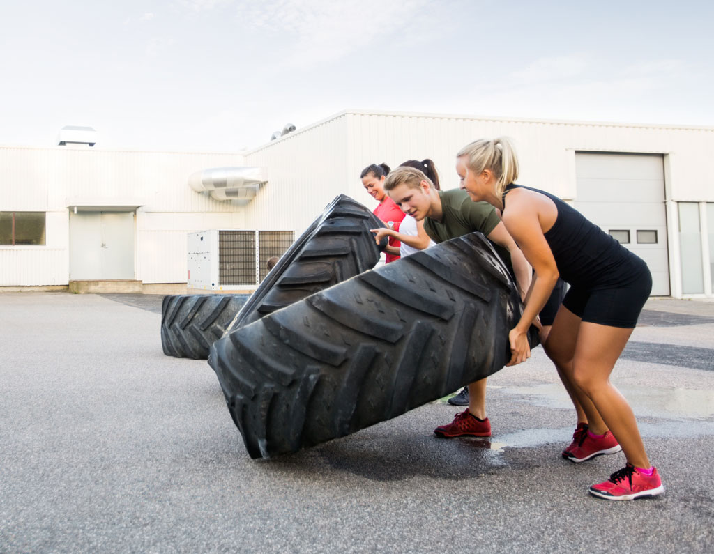 Crossfitters casually flipping tyres.